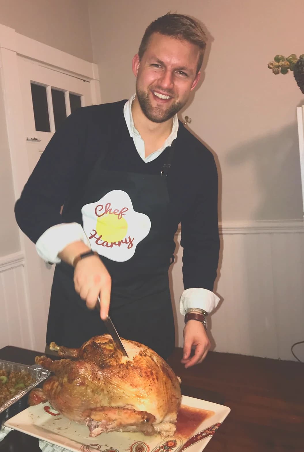 Harrison carving a roast turkey in his Chef Harry apron